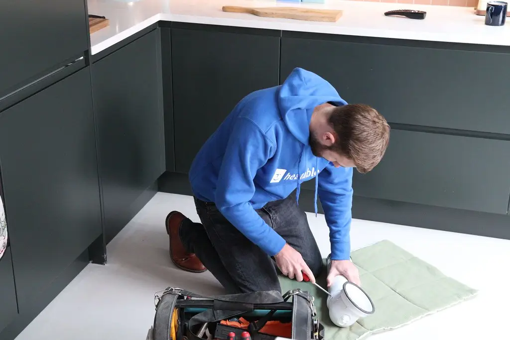 Tradesperson working under a kitchen sink